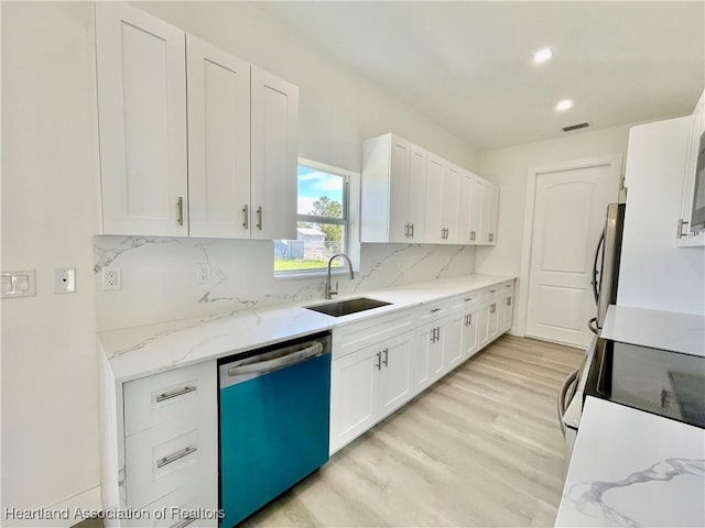 kitchen with white cabinetry, light hardwood / wood-style floors, backsplash, dishwasher, and sink