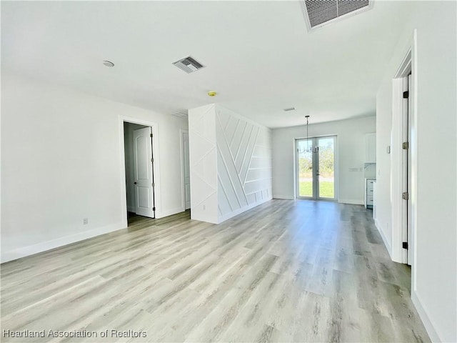 spare room with light hardwood / wood-style floors and french doors