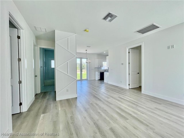 unfurnished living room with french doors and light hardwood / wood-style flooring