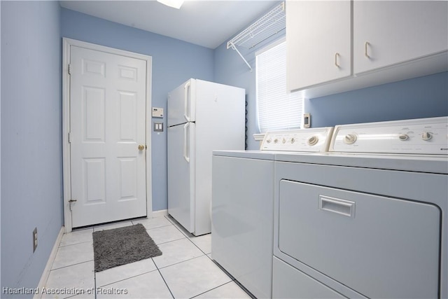 3195 E Pebble Dr, Avon Park, FL 33825 - laundry area featuring washing machine and dryer, cabinet space, light tile patterned floors, and baseboards