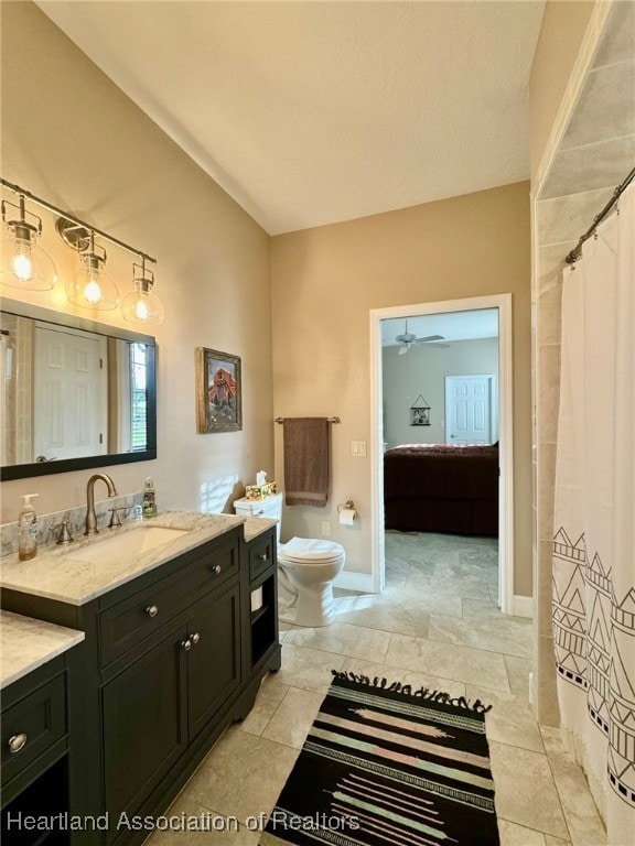 bathroom with tile patterned flooring, vanity, toilet, and ceiling fan