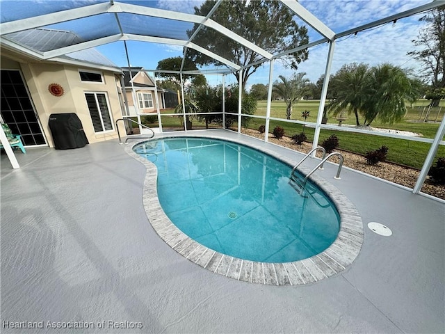 view of pool with a lanai, a patio area, and a yard