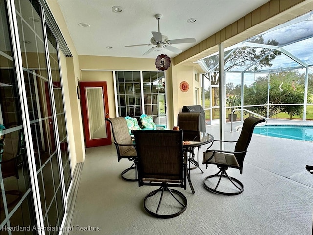 sunroom / solarium featuring ceiling fan and a swimming pool