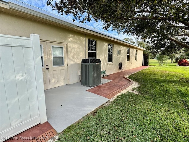 exterior space featuring central AC unit, a patio area, and a yard