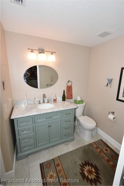 bathroom featuring tile patterned floors, vanity, and toilet