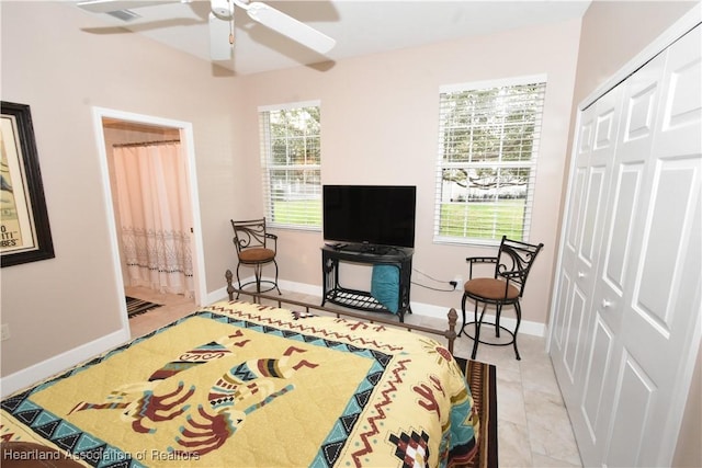 bedroom featuring multiple windows, ceiling fan, a closet, and light tile patterned flooring