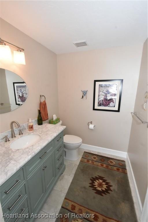 bathroom featuring tile patterned flooring, vanity, and toilet