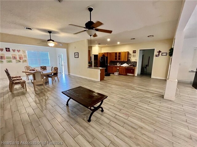 living room with a textured ceiling and ceiling fan