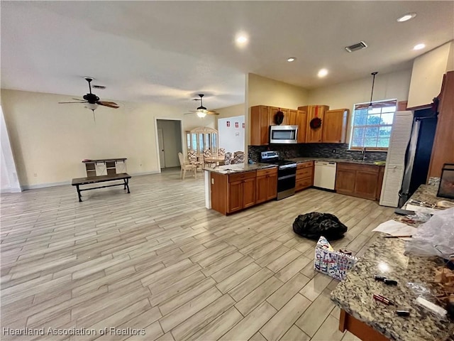 kitchen with pendant lighting, ceiling fan, kitchen peninsula, and appliances with stainless steel finishes