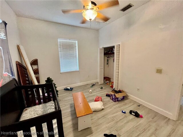 bedroom with ceiling fan, a closet, and light hardwood / wood-style flooring