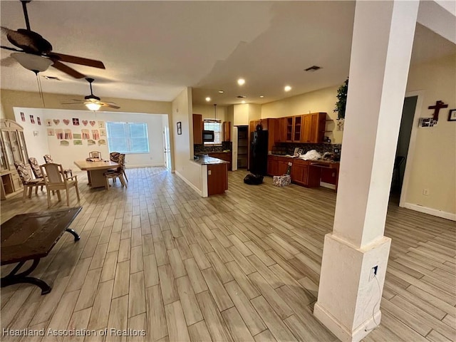 kitchen featuring decorative backsplash, ceiling fan, black appliances, and light wood-type flooring