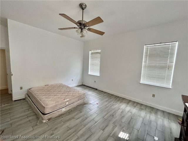 unfurnished bedroom featuring light wood-type flooring and ceiling fan