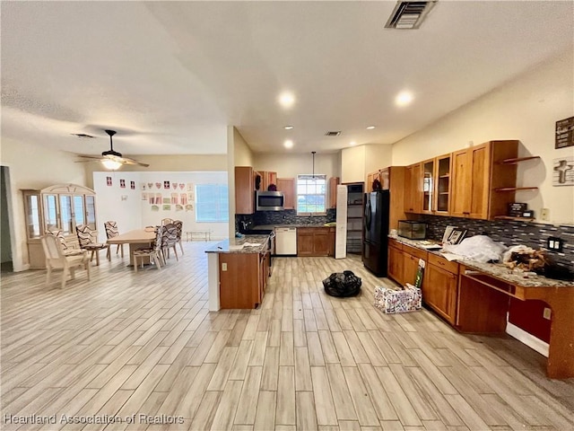 kitchen with black refrigerator, light stone countertops, dishwashing machine, ceiling fan, and light hardwood / wood-style floors