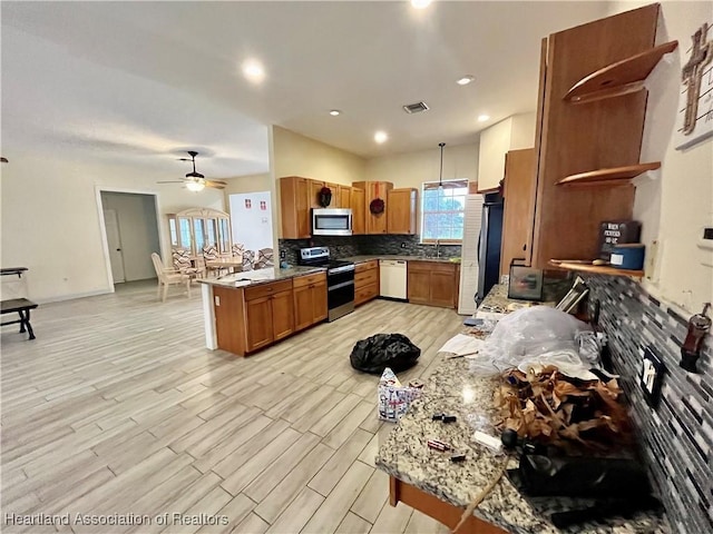 kitchen with kitchen peninsula, appliances with stainless steel finishes, decorative backsplash, ceiling fan, and decorative light fixtures