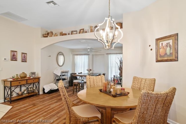 2033 Ashley Oaks Cir, Sebring, FL 33870 - dining space with baseboards, visible vents, ceiling fan with notable chandelier, wood finished floors, and arched walkways