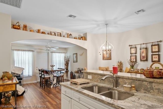 2033 Ashley Oaks Cir, Sebring, FL 33870 - kitchen with a sink, arched walkways, visible vents, and wood finished floors