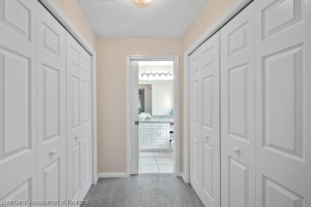 2033 Ashley Oaks Cir, Sebring, FL 33870 - hallway featuring light carpet, baseboards, and light tile patterned floors