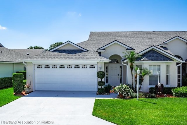 2033 Ashley Oaks Cir, Sebring, FL 33870 - view of front of property with driveway, a garage, stucco siding, roof with shingles, and a front lawn