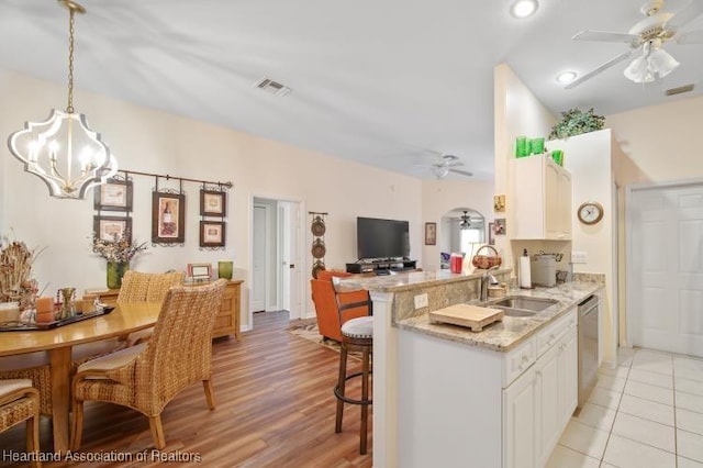 2033 Ashley Oaks Cir, Sebring, FL 33870 - kitchen featuring a breakfast bar area, visible vents, stainless steel dishwasher, and ceiling fan with notable chandelier