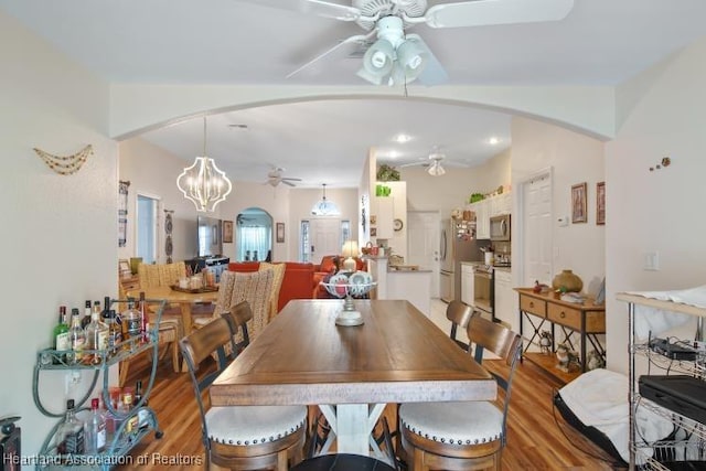 2033 Ashley Oaks Cir, Sebring, FL 33870 - dining space featuring light wood finished floors, ceiling fan with notable chandelier, arched walkways, and recessed lighting