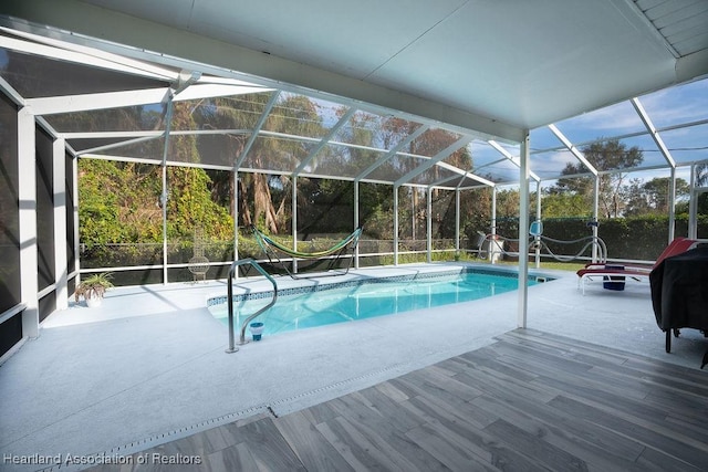 view of swimming pool with glass enclosure and a patio area