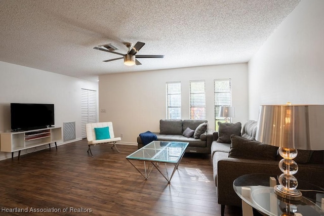 living room featuring a textured ceiling, ceiling fan, and dark wood-type flooring