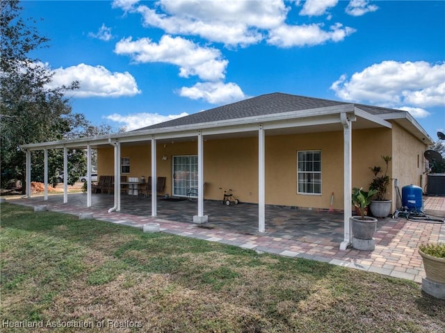 back of house featuring a patio and a lawn