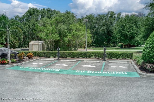 2351 Lakeview Dr Unit 219, Sebring, FL 33870 - uncovered parking lot featuring a shed and view of scattered trees