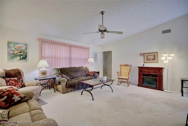 living room featuring ceiling fan, a textured ceiling, light carpet, and vaulted ceiling