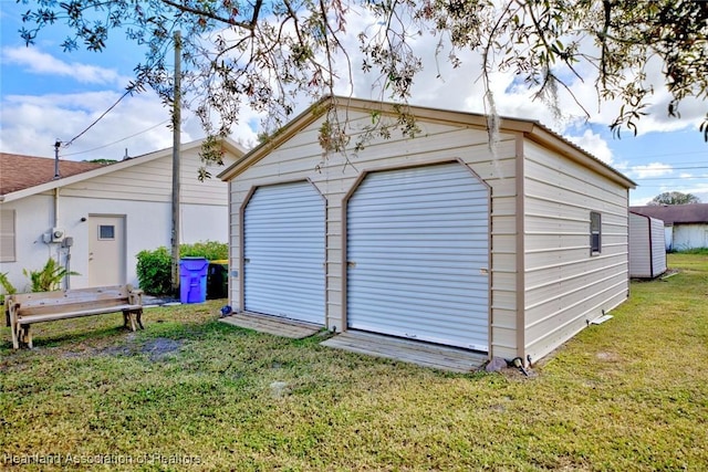 view of outdoor structure featuring a garage and a lawn