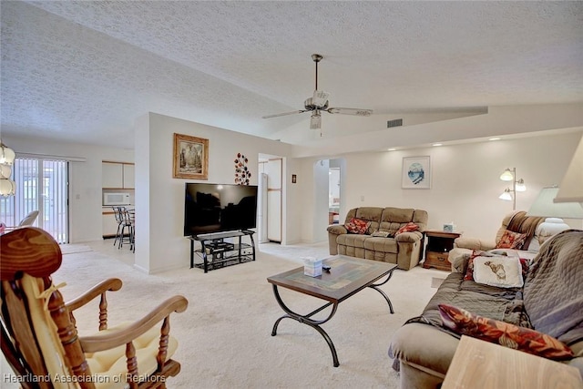 carpeted living room with ceiling fan, lofted ceiling, and a textured ceiling