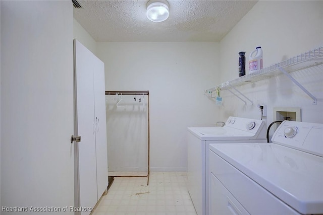 laundry room with washer and dryer and a textured ceiling