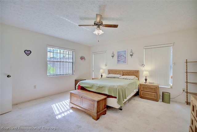 bedroom with light carpet, a textured ceiling, and ceiling fan