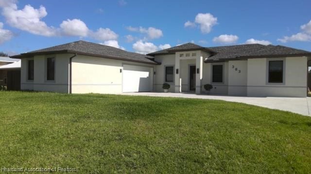 view of front of property with stucco siding, an attached garage, driveway, and a front lawn