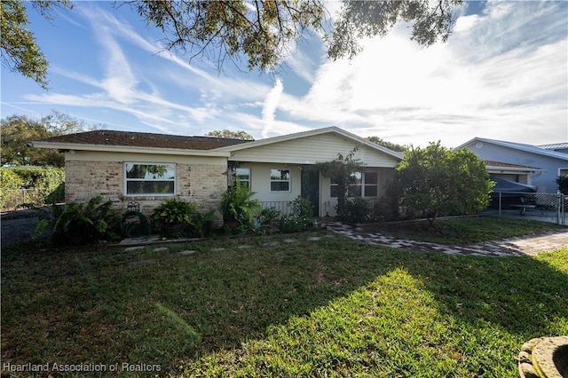 single story home featuring a front lawn