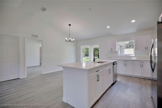 2731 W Albatross Rd, Avon Park, FL 33825 - kitchen with white cabinets, light wood-style flooring, an island with sink, light countertops, and vaulted ceiling