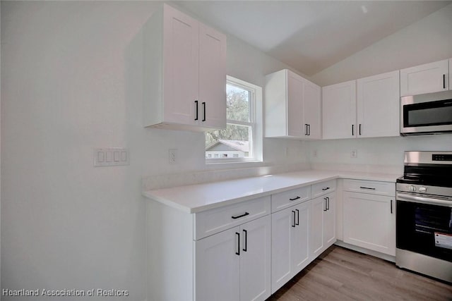 2731 W Albatross Rd, Avon Park, FL 33825 - kitchen featuring appliances with stainless steel finishes, light countertops, lofted ceiling, white cabinetry, and light wood-style flooring