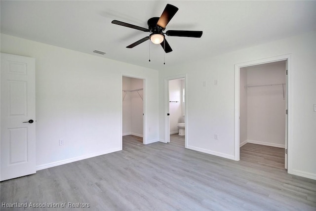 2731 W Albatross Rd, Avon Park, FL 33825 - unfurnished bedroom featuring a spacious closet, a closet, wood finished floors, and connected bathroom