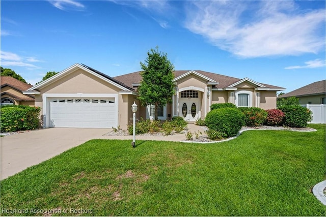 302 Ruby Ln, Winter Haven, FL 33884 - ranch-style house with stucco siding, an attached garage, concrete driveway, a front yard, and french doors