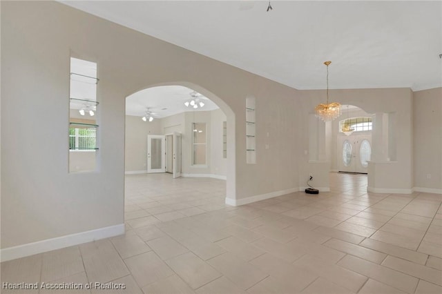 302 Ruby Ln, Winter Haven, FL 33884 - spare room featuring arched walkways, light tile patterned flooring, a ceiling fan, and plenty of natural light
