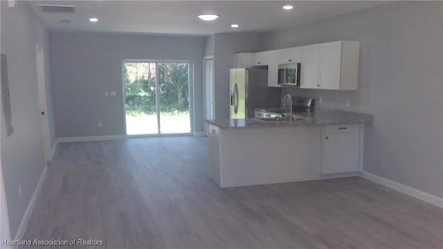 kitchen featuring stainless steel appliances, sink, wood-type flooring, and white cabinets