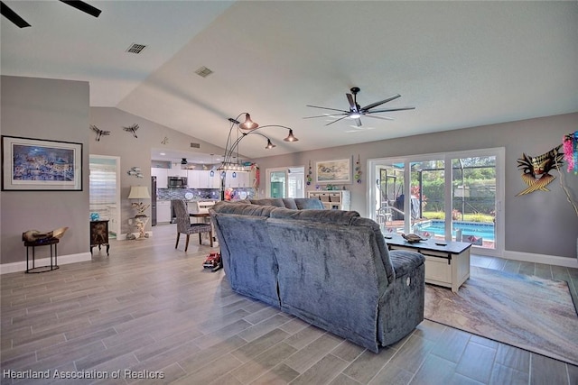 living room with ceiling fan, light hardwood / wood-style flooring, and lofted ceiling