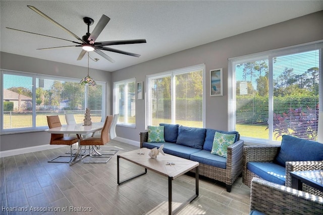 sunroom / solarium featuring plenty of natural light and ceiling fan