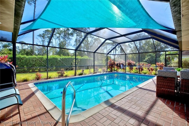 view of pool with glass enclosure and a patio