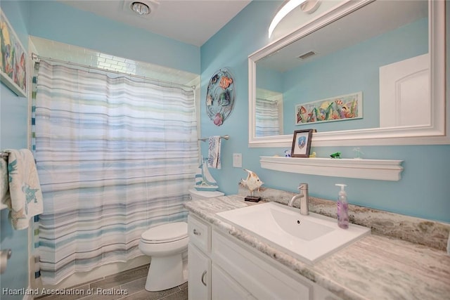 bathroom with vanity, toilet, and curtained shower