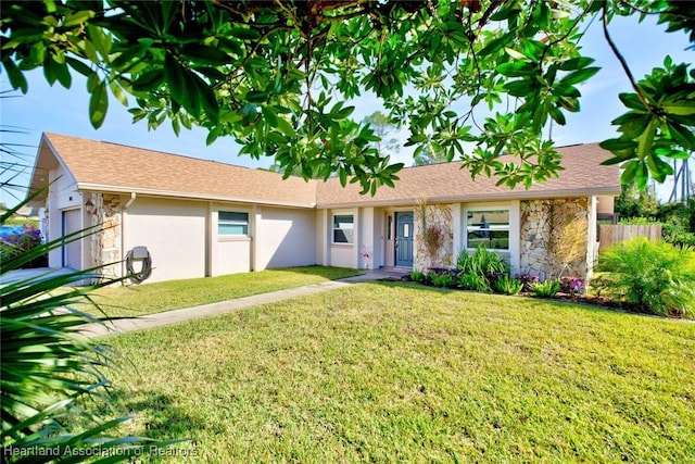 ranch-style house featuring an attached garage, stone siding, a front lawn, and stucco siding