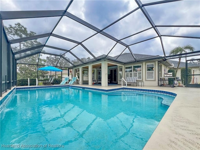 pool featuring a patio area and glass enclosure