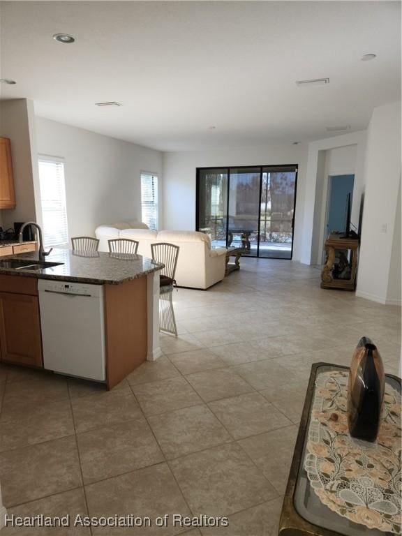 kitchen featuring white dishwasher, a kitchen bar, and sink