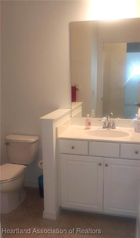 bathroom with tile patterned floors, vanity, and toilet