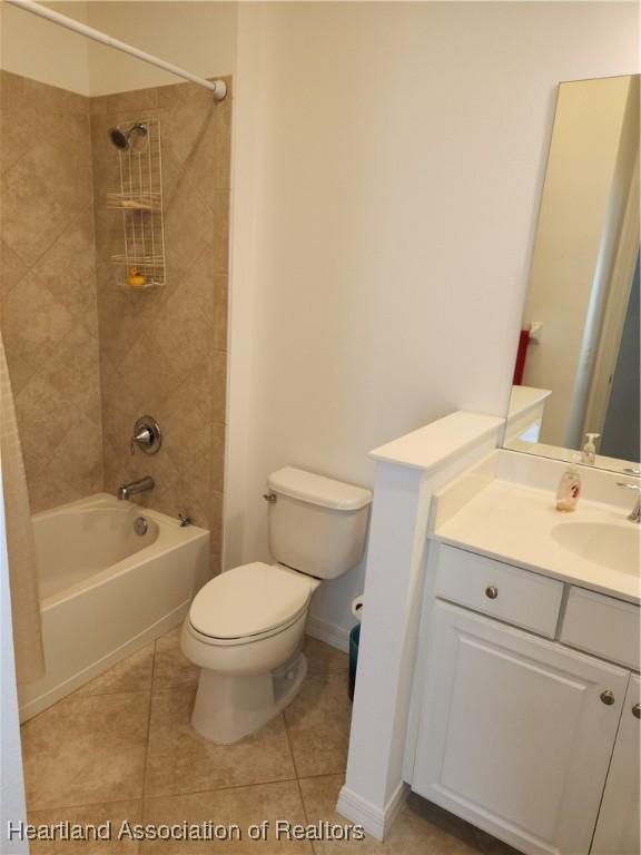 full bathroom featuring tile patterned floors, tiled shower / bath combo, toilet, and vanity